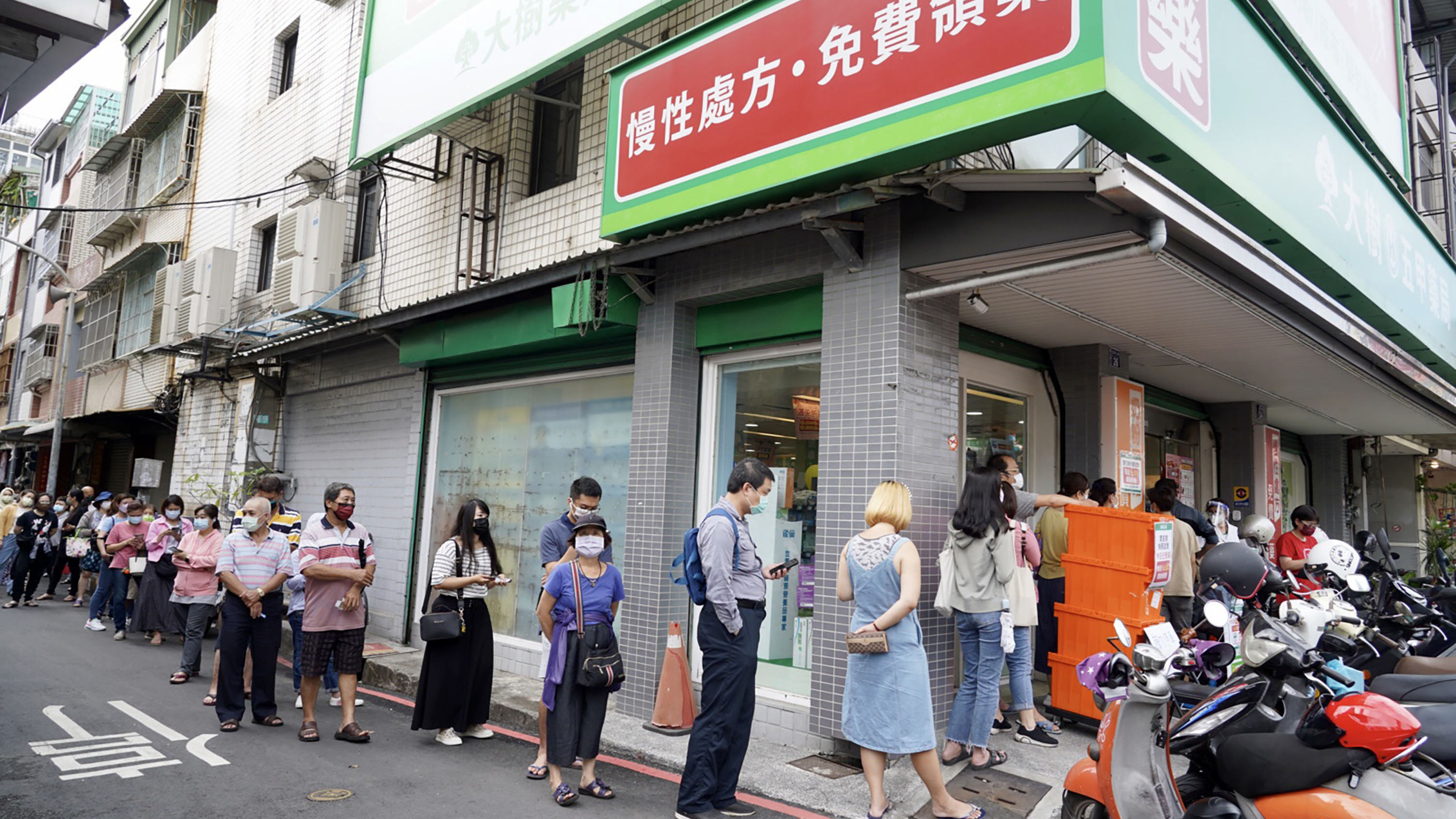 圖集｜本土疫情升溫 快篩一劑難求！台灣民眾在藥店外大排長龍